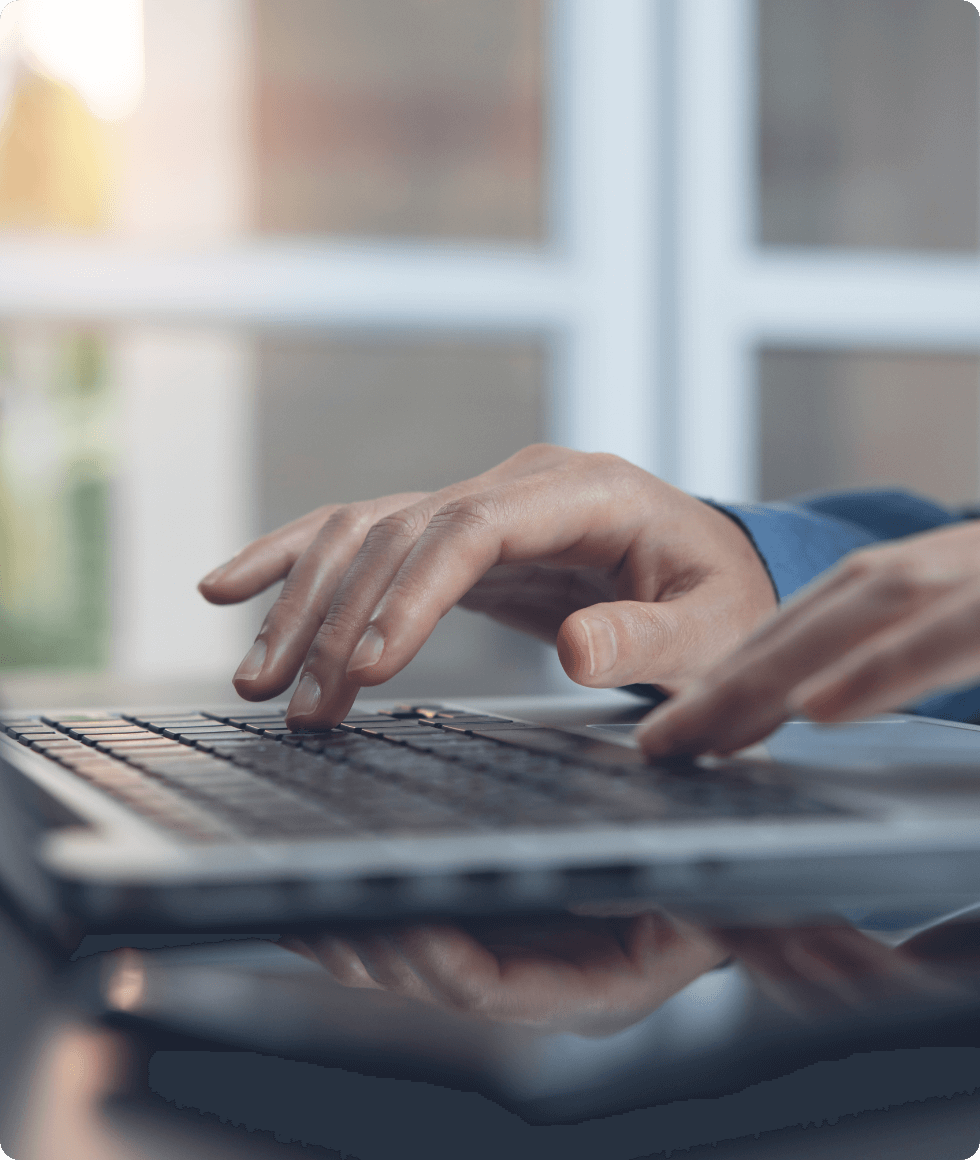 ノートパソコンにタイピングする男性の手
